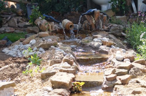 Click Here To Enlarge This Photo Of Creative stream and pond with wine bottles